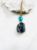 Handmade necklace featuring a small Turquoise stone atop a larger Black Tourmaline stone, on a golden chain.